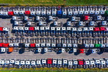 Lots of freight trailers. Cars are in several rows. Truck parking. Aerial view vertically down.