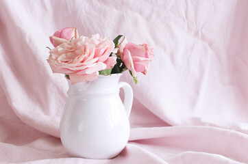 Fototapeta na wymiar Spring, summer still life scene. Vintage wedding feminine styled photo, floral composition. Bouquet of pink roses in a white vase.