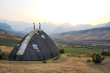Drakensberg mountains with Didima camp huts, South Africa, against the setting sun (travel...