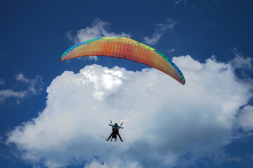 Parapentiste volant devant un cumulus