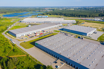 Aerial top view of the large logistics park with warehouse, loading hub with many semi-trailers trucks.