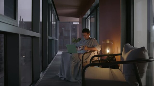 Handsome Caucasian Man Having A Cold Videoconferencing In A Modern Apartments Balcony Using His Laptop