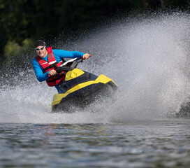 Riding on a water scooter.  Man on jet ski rides very close