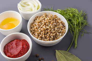 Recipe of cooking vegetarian buckwheat cutlets or meatballs. Flat lay layout of Ingredients: buckwheat, onion and egg. Homemade food concept.