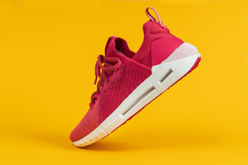 Running sports shoe on yellow background. Running shoe, sneaker or trainer. Women's athletic shoe....