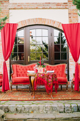 Festive table setting in national Russian style. Red color in decor and decoration of event.