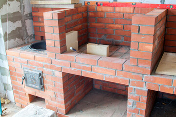 stage of construction of barbecue area in gazebo under roof of main country house