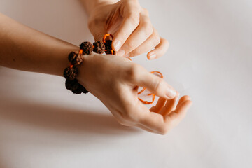 Rudraksha beads bracelet in female prayer's hand, close up