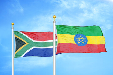 South Africa and Ethiopia two flags on flagpoles and blue sky