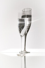 transparent insulated glass glass with liquid and bubbles on a white background with a contrasting shadow close up