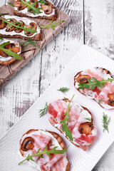 Bruschetta assortment with cream cheese, champignons, pancetta meat, vegetables and greenery