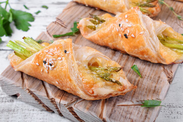 Green asparagus and cheese puff pastry folded as envelope and topped with sesame seeds