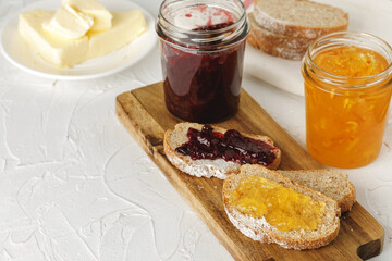 Slice of fresh bread with butter and jam on table