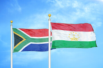 South Africa and Tajikistan two flags on flagpoles and blue sky