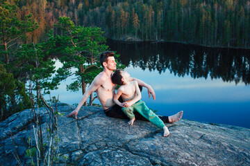 Fototapeta premium middle age man with little cute son doing sport yoga on the top of the mountain together, happy family lifestyle people outdoor, summer wild nature for training