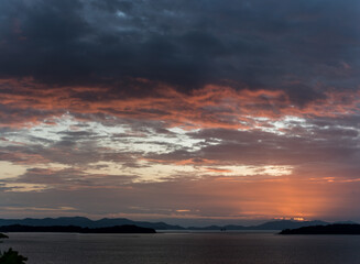 sea, sky with dramatic clouds at golden sunset in phuket  