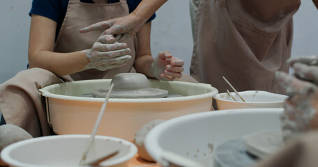 Hand work on pottery wheel, shaping a clay pot