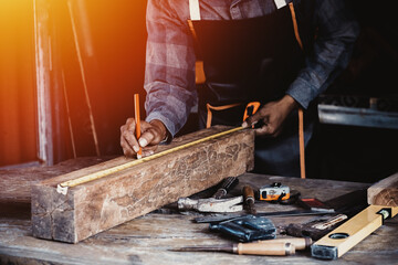 Carpenter working on woodworking machines in carpentry shop.