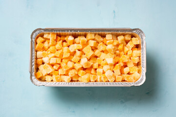 Frozen pumpkin on a blue surface, flat lay, horizontal orientation.