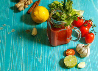 Detox cocktail of tomatoes, lemon and celery on a blue wooden background, top view, copy of space