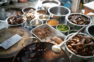 Chef hand cooking hot boiled soup noodle with duck meat in local traditional restaurant