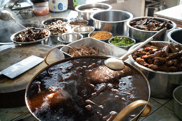 Chef hand cooking hot boiled soup noodle with duck meat in local traditional restaurant