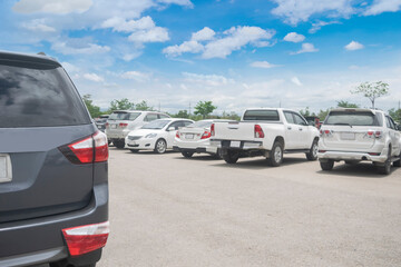 Car parked in large asphalt parking lot and back car close up with cloudy sky background. Outdoor...