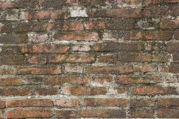 Old red brick wall on the side of the road
