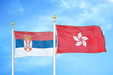 Serbia and Hong Kong two flags on flagpoles and blue sky