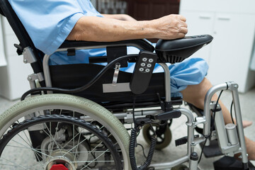 Asian senior or elderly old lady woman patient on electric wheelchair with remote control at...