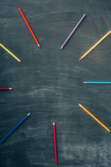 top view of empty frame of multicolored pencils on green chalkboard