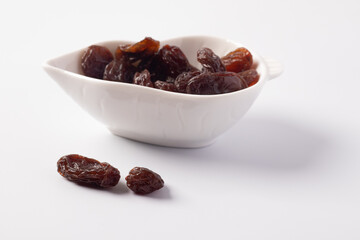 Black currant in a white ceramic cup on a white background