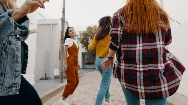 Female friends dancing together outdoors. Group of women having fun and dancing.
