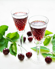 Cherry liqueur in a glass and fresh fruits