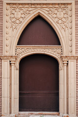 Brown original doors with patterns and columns and arch and hand sculpting