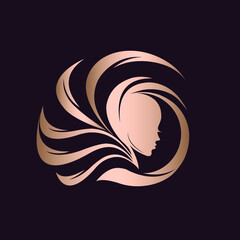 Hair salon and beauty studio logo.Cosmetics and spa icon.Woman with elegant decorative hairstyle.Young lady portrait.Pretty face silhouette isolated on dark background.Shiny metallic rose gold color.