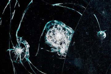 Cracks in car glass on a black background.