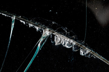 Cracks in car glass on a black background.