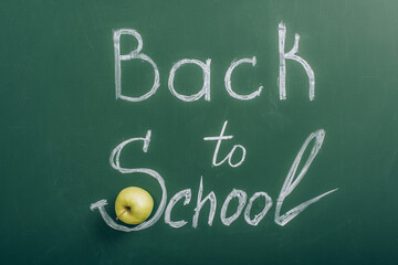 top view of ripe apple near back to school lettering on green chalkboard