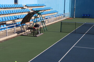 tennis court arena with hard surface and tribunes