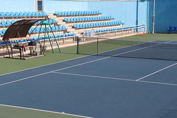 tennis court arena with hard surface and tribunes