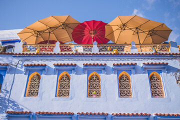 Blue town in Morocco, Chefchaouen. Architecture in old medina. Famous blue city in north africa. Colorful umbrellas on the roof of building, cafe with the view. Blue sky.