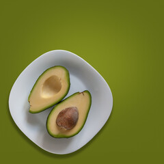 Fresh avocado. Two halves on white dish. Cut out on green background. Square blank for internet...