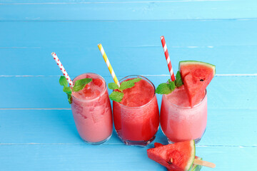 3 glasses cold watermelon juice smoothie refreshing drinks for a healthy summer on blue background.