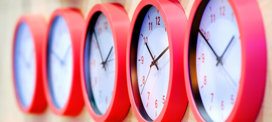 Blurred background. Selective focus. The red-edged clock is arranged in a row.