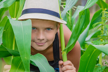 Summer boy farmer in a child hat in nature happy on nature in the village