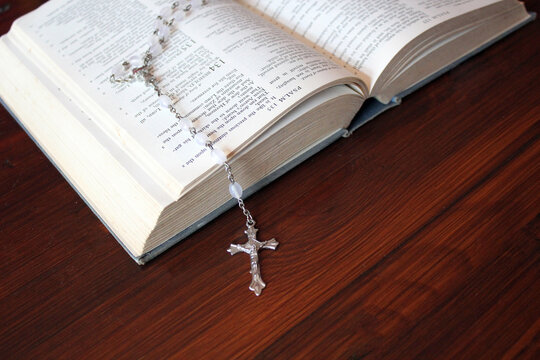 bible and rosary beads for a catholic to pray  background with copy space  - stock photo