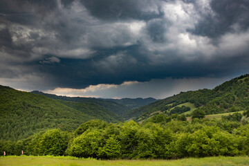 Fototapeta na wymiar Storm clouds above meadow with green grass