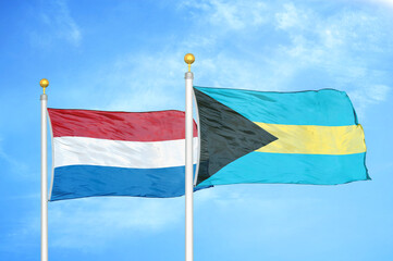 Netherlands and Bahamas two flags on flagpoles and blue sky
