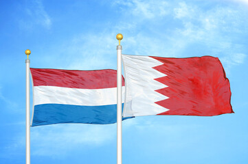 Netherlands and Bahrain two flags on flagpoles and blue sky